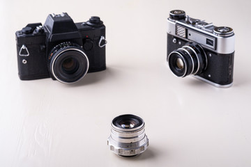Old vintage retro two black and silver photo film camera with lens copy space angle view on white background