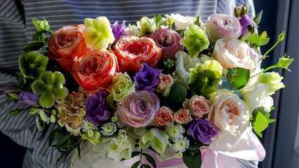 Florist woman holding a beautiful flower arrangement in a flower shop floral background
