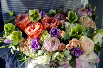 Florist woman holding a beautiful flower arrangement in a flower shop floral background