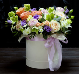 beautiful flower arrangement in a hat box on a black background floral background