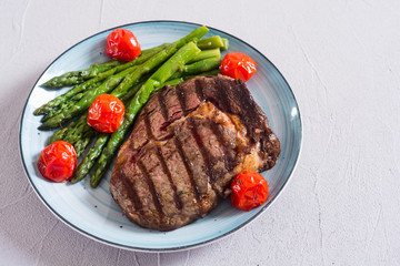 Grilled beef steak ribeye with cherry tomatoes and asparagus