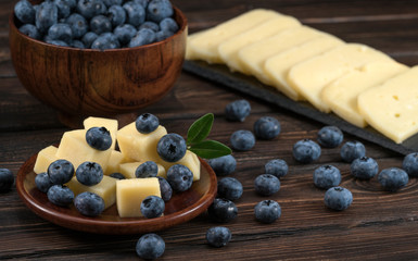 .cheese and blueberries on a wooden background