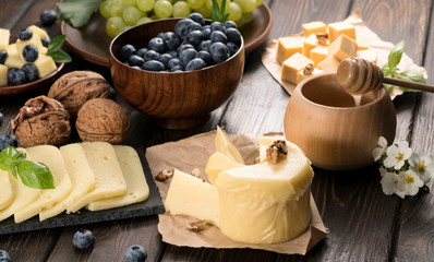 .cheeses honey and pigeon on wooden background