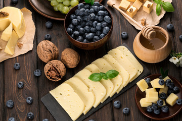 cheeses honey and pigeon on wooden background