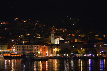Fototapeta na wymiar Panoramic night view of Makarska city center from the sea in Makarska, Croatia on June 16, 2019.