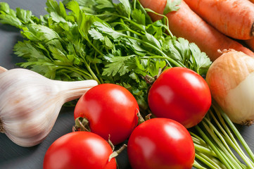 Set of different fresh whole ripe vegetables lies on dark concrete table
