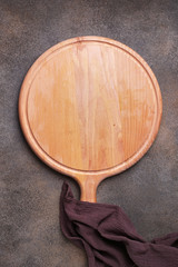 Fototapeta premium Empty pizza platter and napkin on grunge background. Kitchen accessories for serve. Top view with copy space