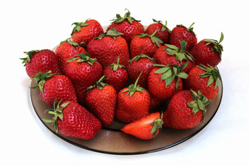 fresh strawberries on a plate, close-up, on a white background