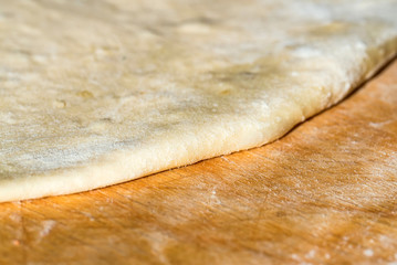 Close up white raw dough on wooden board