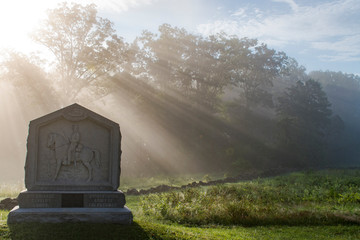 Early morning sunrays backlight a civil war monument