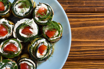 Zucchini rolls with cream cheese , tomatoes and dill