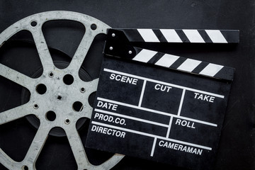 Watch film in cinema with video tape and clapperboard on black background top view