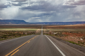 Long highway in the american desert, cloudy sky