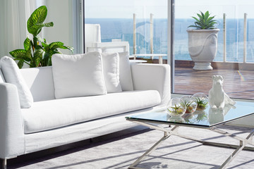 Interior of the living room of the hotel. Beautiful living room with white sofa. White Concept Living Room Interior. Modern bed room interior in Luxury villa. White colours, big window