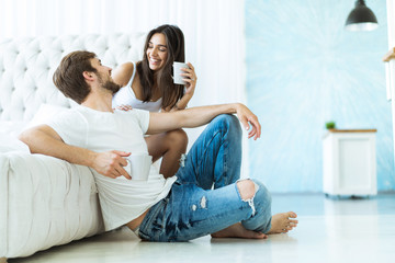 Obraz premium Loving young couple hugging and relaxing on sofa at home.