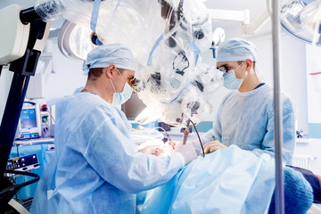 Spinal surgery. Group of surgeons in operating room with surgery equipment. Laminectomy