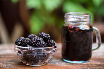 Close up fresh mulberries fruit in bowl and juice in jar