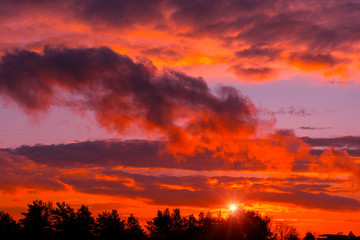 Fototapeta na wymiar Fiery orange sunset colorful and speckled clouds.