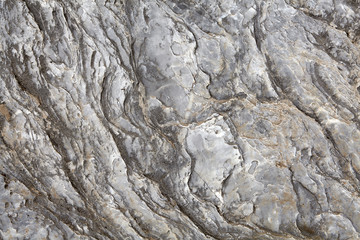 Unprocessed rock surface of natural gray stone.