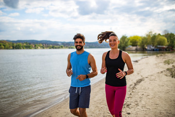 Running couple jogging on beach 