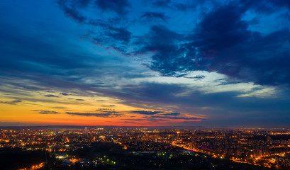 night metropolis with stunning orange sunset and blue sky view from the height of bird flight. Yekaterinburg, Russia