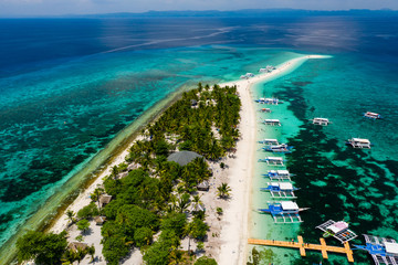 Aerial view of traditional boats moored off a tiny tropical island in the Philippines (Kalanggaman)