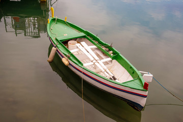 High angle view of an old green and white rowboat with the oars on board with sea water background, Imperia, Liguria, Italy