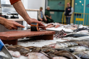 Fish monger cutting salmon at the market