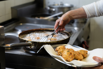 Cod fish fritters being fried in kitchen