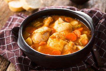 Fresh homemade chicken stew with potato, carrot and celery, seasoned with paprika in rustic bowl...