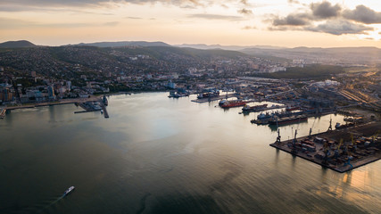 Pier with a lighthouse in the city of Novorossiysk from a height where you can see the sea, the bay at sunset.