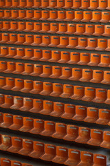 many empty vintage stadium orange seats pattern, vertical photo