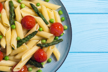 Penne pasta salad with asparagus , tomatoes and peas