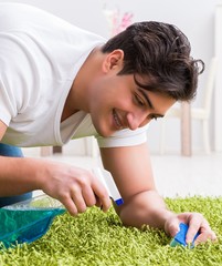 Young husband man cleaning floor at home