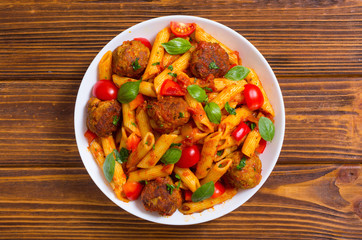 Italian penne pasta with meatballs and tomatoes