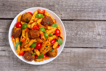 Italian penne pasta with meatballs and tomatoes