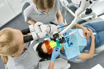 Pretty woman's teeth treatment in dental clinic