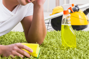 Young husband man cleaning floor at home