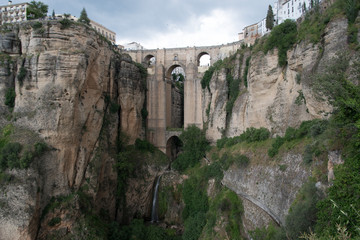 Fototapeta na wymiar Puente Nuevo one of the most spectacular bridges in Spain spans a narrow chasm that divides the city of Ronda. 