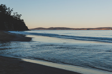 Obraz premium view of the water on a Tasmanian beach in South Hobart at dusk