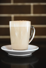 Cup of latte on black background. Photo made in dark key.