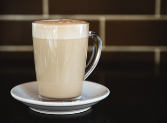 Cup of latte on black background. Photo made in dark key.