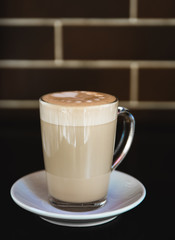 Cup of latte on black background. Photo made in dark key.