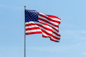 American Flag waving on pole with vibrant colored stars and stripes