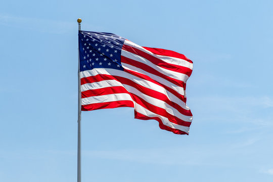 American Flag waving on pole with vibrant colored stars and stripes