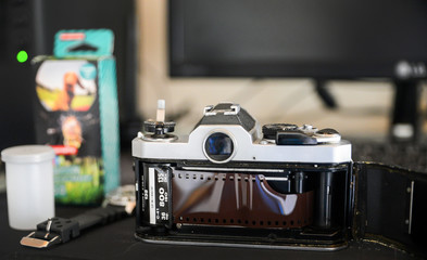 Analog life concept, Retro classic film camera and film roll on desktop.