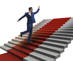 Young businessman climbing stairs and red carpet on white backgr