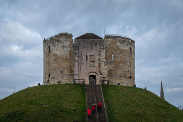 YORK, ENGLAND, DECEMBER 12, 2018: red dressed family entering to the Clifford's Tower castle in the historic city of York.