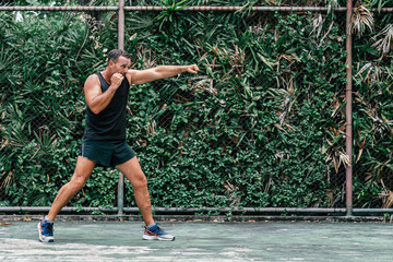 Better Body. Better Life. Muscular man in black sportswear doing exercises. Copy space on the left side.