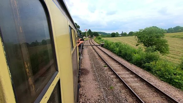 Looking out of the widow from a vintage steam railway carriage as the engine travels along the tracks over points to change lines.